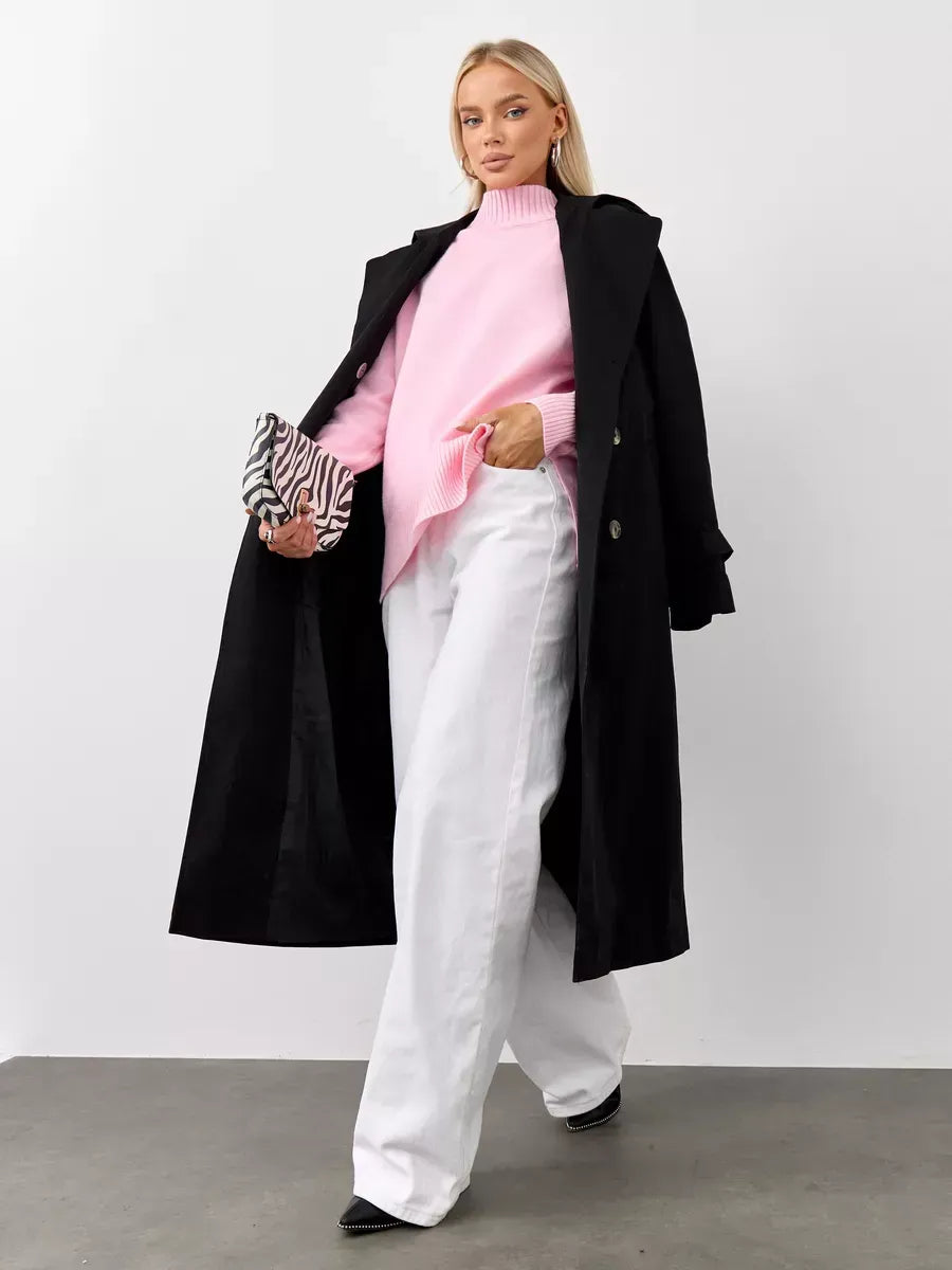 Stylish model wearing the Rosette Sweater by Lauven with oversized pink cashmere knitwear and white trousers.