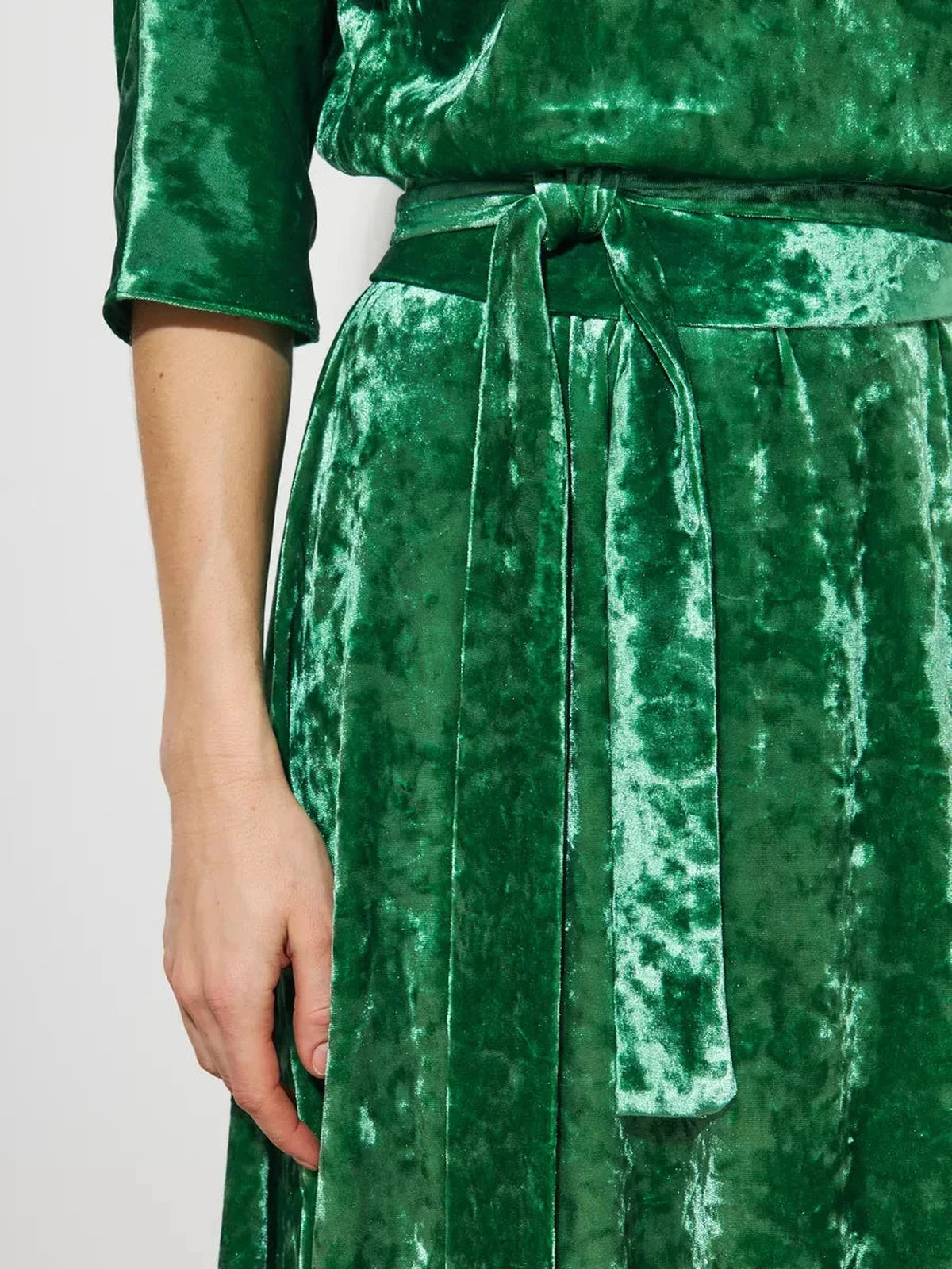 Close-up of the Verdea Maxi Dress by Lauven, showcasing its elegant green crushed velvet texture and tied belt.