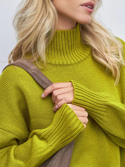 Close-up of model wearing Vesper Sweater by Lauven in pistachio green with high turtleneck and oversized fit.