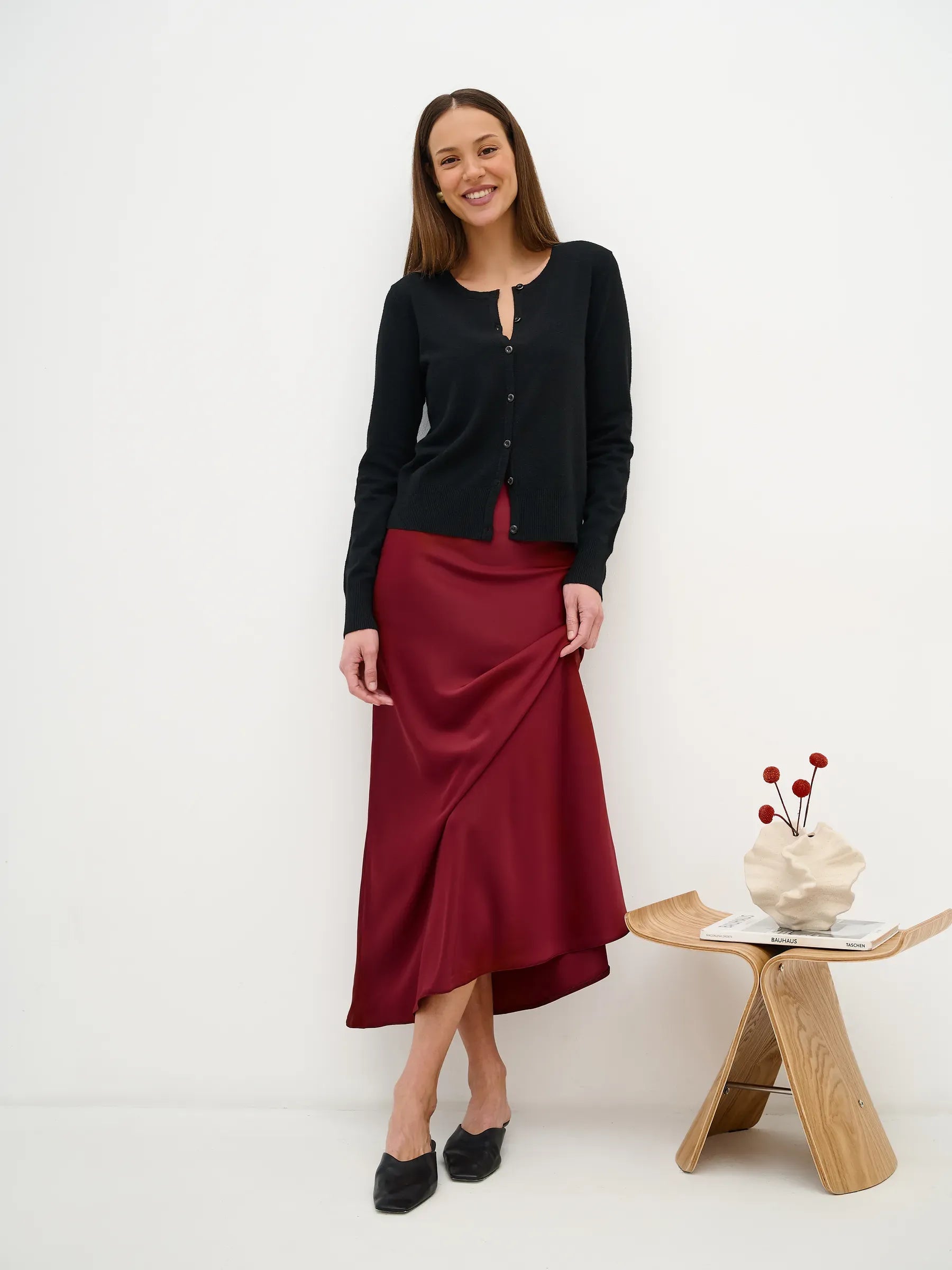 Orion Cardigan by Lauven: sleek black knitwear styled with a burgundy skirt, perfect for year-round sophistication.