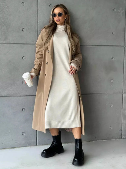 Celeste Midi Dress by Lauven, featuring a soft beige knit design styled with a trench coat and bold black boots.
