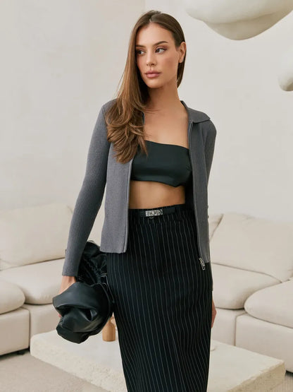 Model showcasing the Orion Cardigan by Lauven, a dark gray ribbed knit cardigan with a two-way zipper.