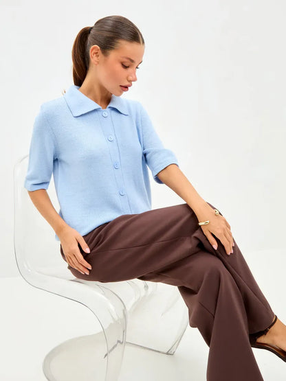 Lauven Alba Cardigan in lightweight blue wool blend, featuring a button closure, worn with brown trousers.