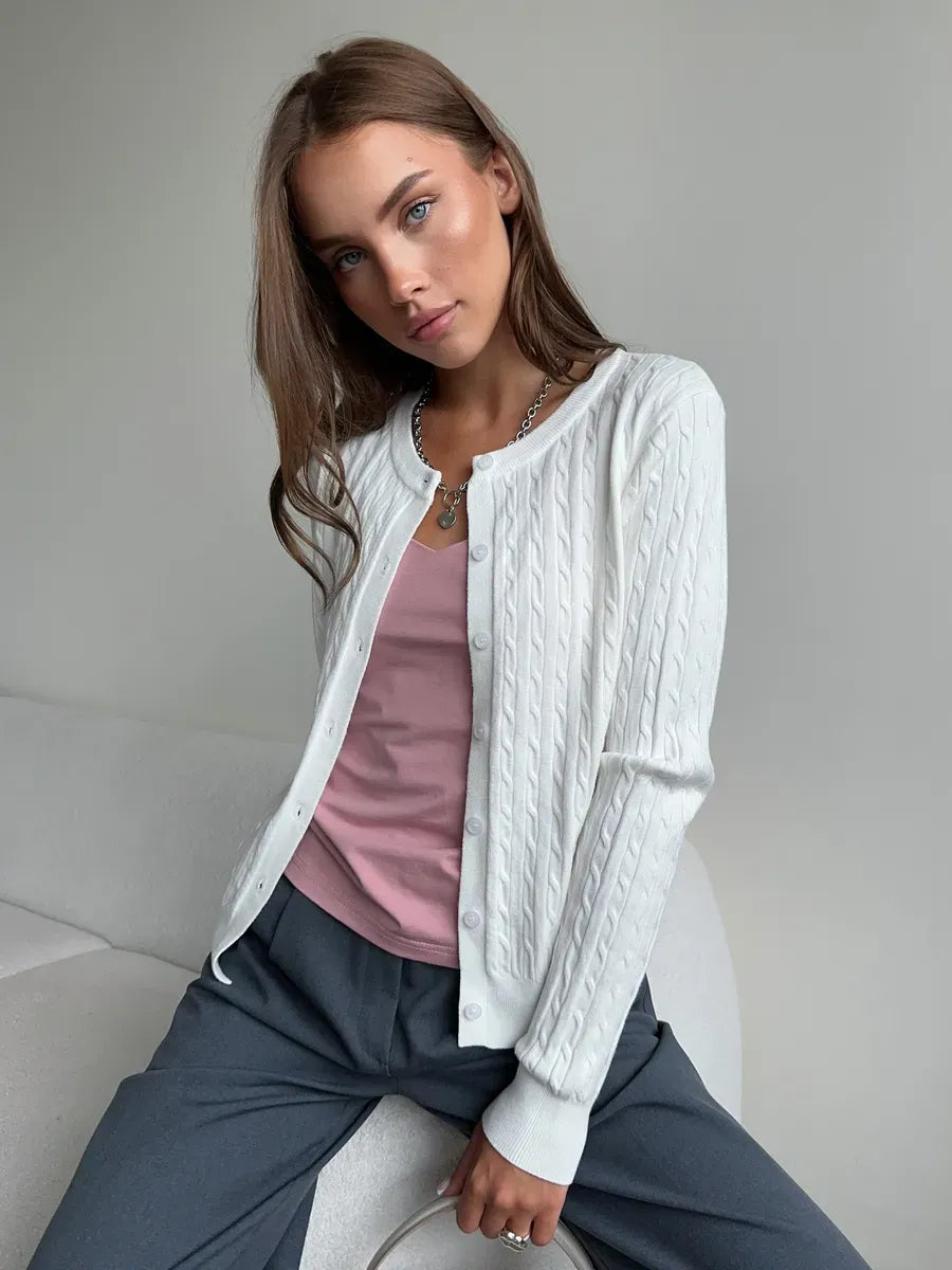 Model wearing Lauven Ivory Cardigan, a lightweight cable knit sweater, paired with a pink top.