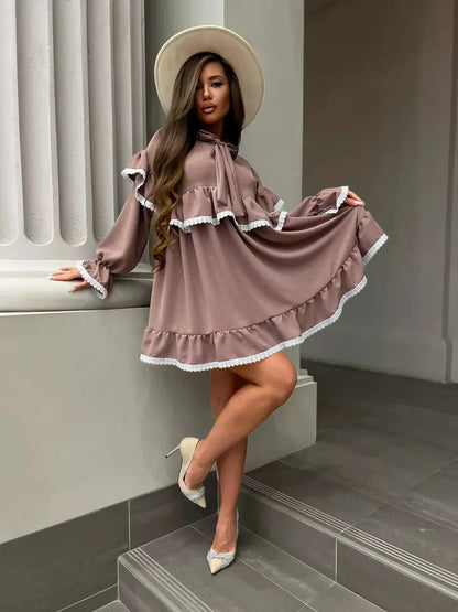 Aurora Mini Dress by Lauven, featuring soft ruffles and lace trim, styled elegantly with a wide-brim hat.