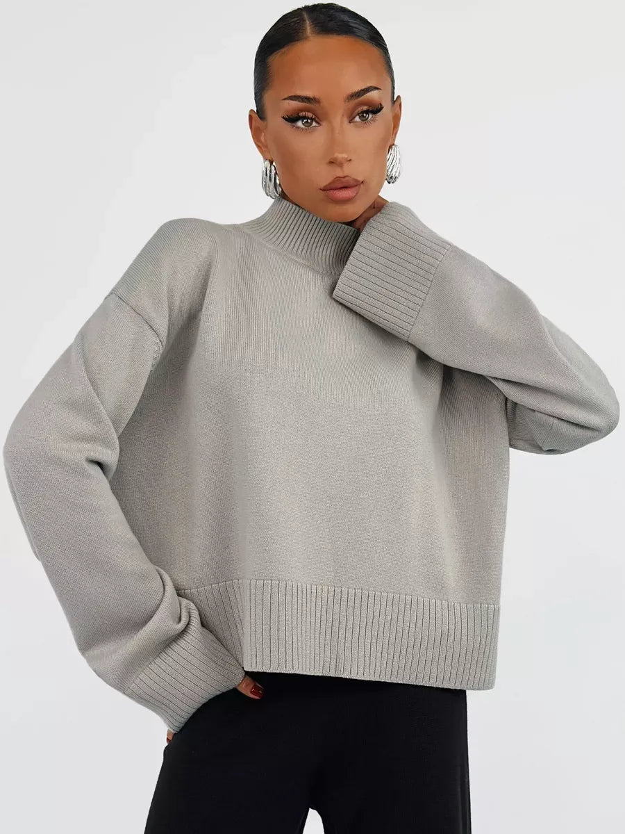 Stylish woman modeling the Arden Sweater by Lauven, an oversized gray cotton blend knit.