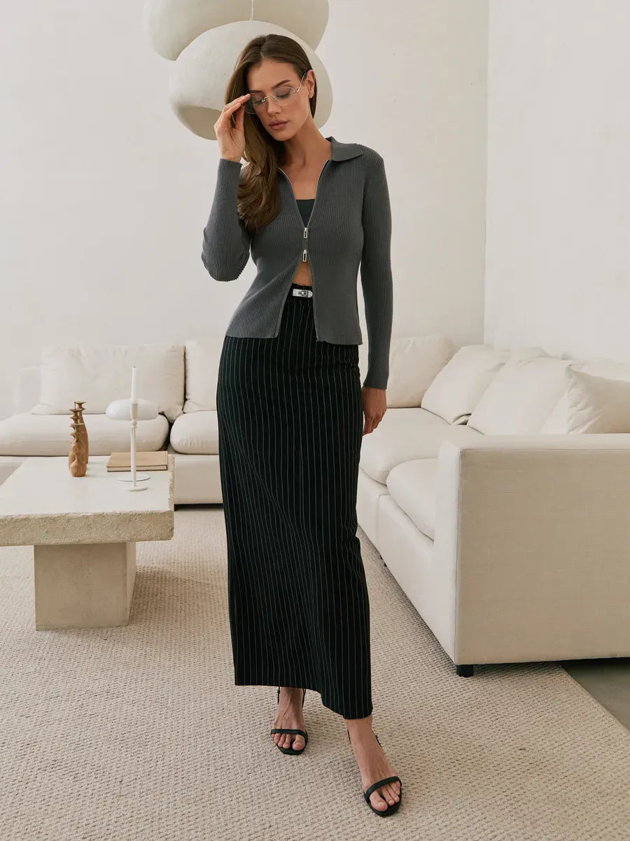 Orion Cardigan by Lauven in dark gray ribbed knit with two-way zipper, styled with a long skirt for modern elegance.