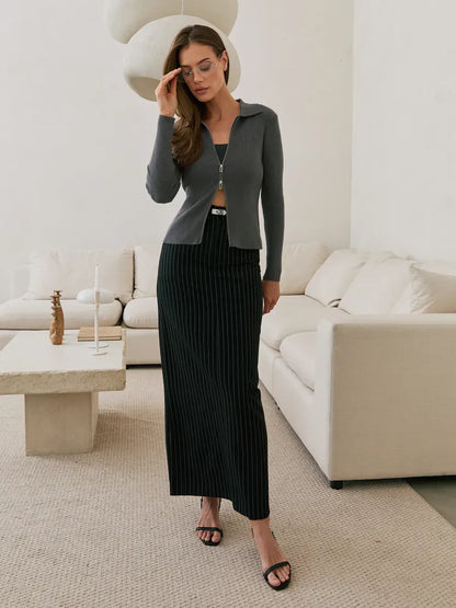 Orion Cardigan by Lauven in dark gray ribbed knit with two-way zipper, styled with a long skirt for modern elegance.