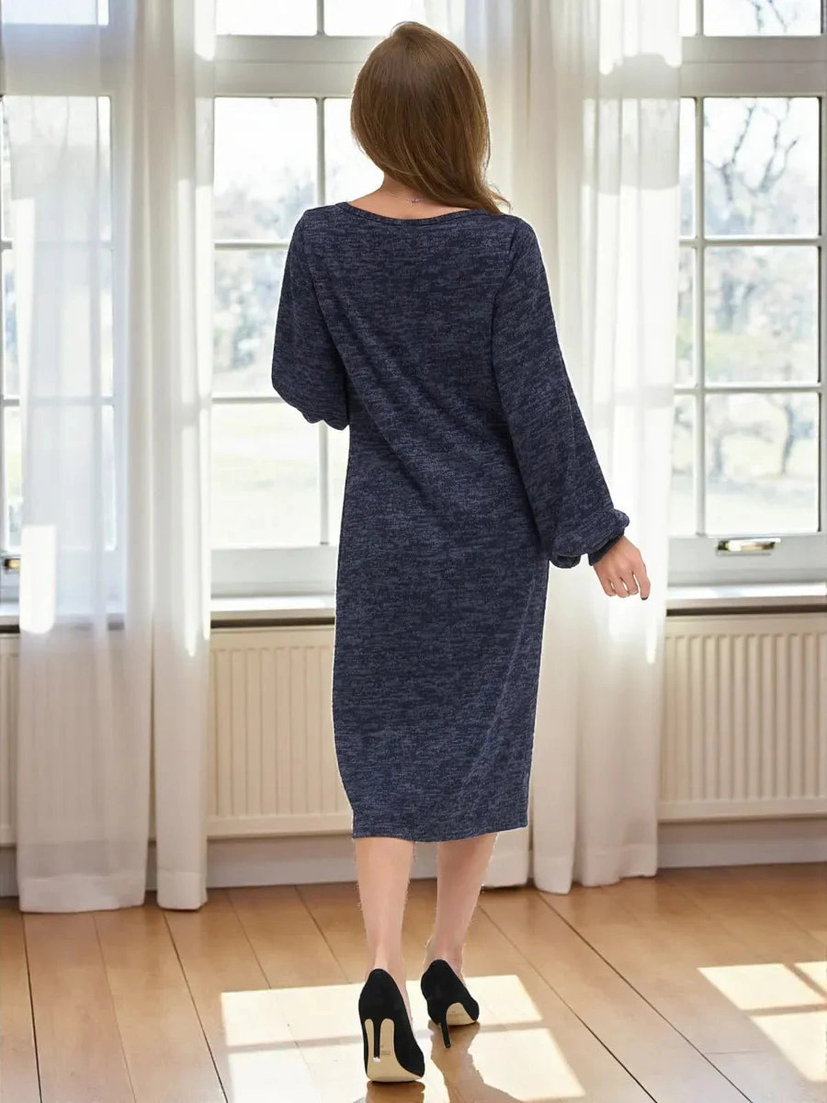 Woman wearing Celeste Midi Dress by Lauven, showcasing elegant knit design and balloon sleeves in deep navy melange.