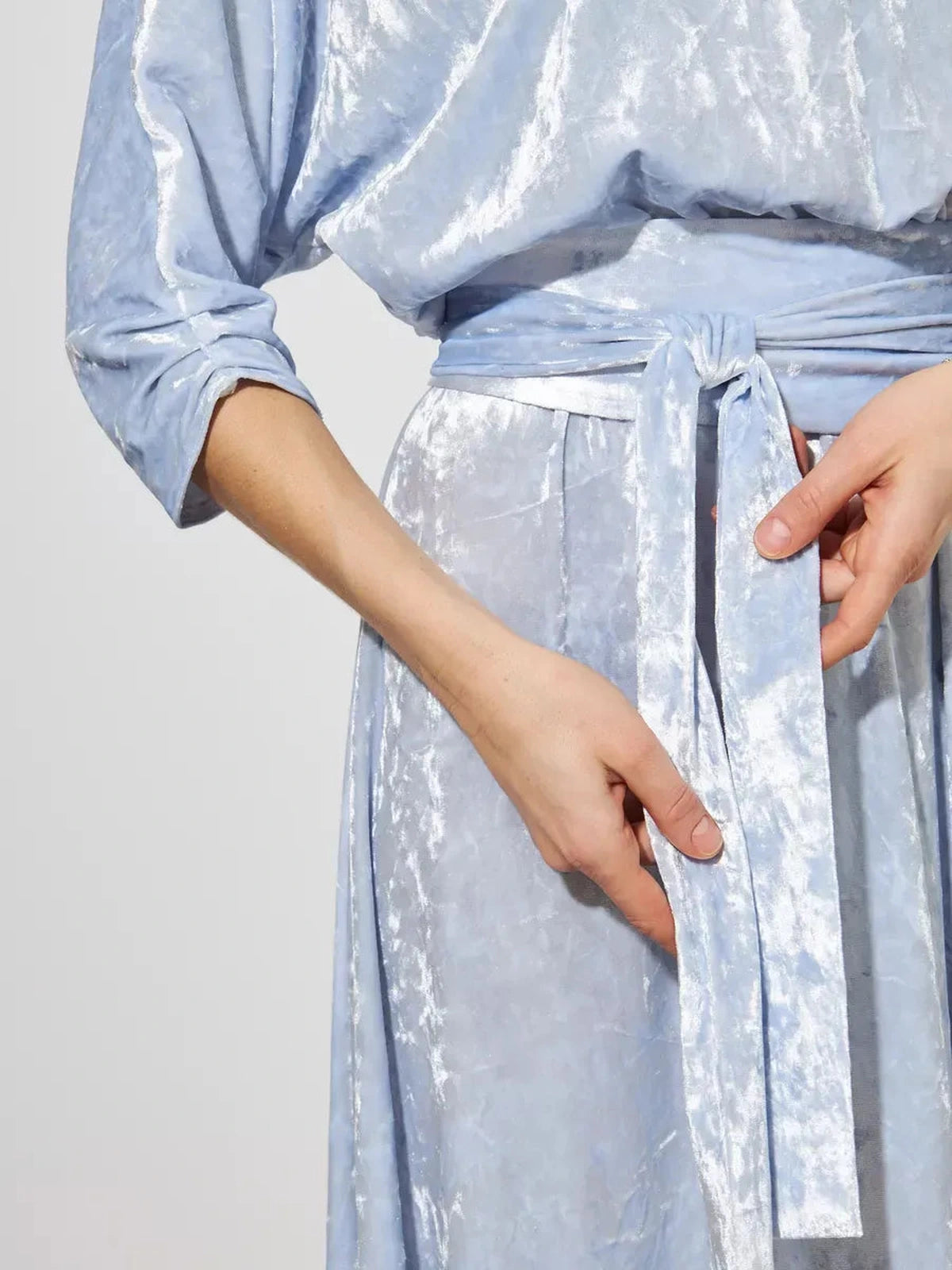 Detail of the waist tie on the Lunara Maxi Dress by Lauven, showcasing light blue velvet fabric and elegant design.