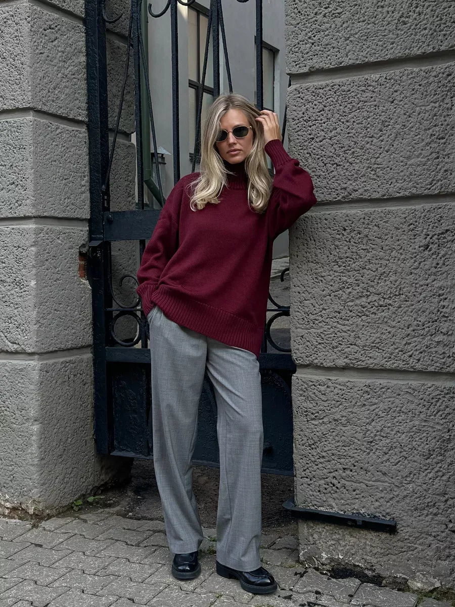 Aurelia Sweater - Oversized women's wool knit in burgundy by Lauven, styled with gray trousers and sunglasses.