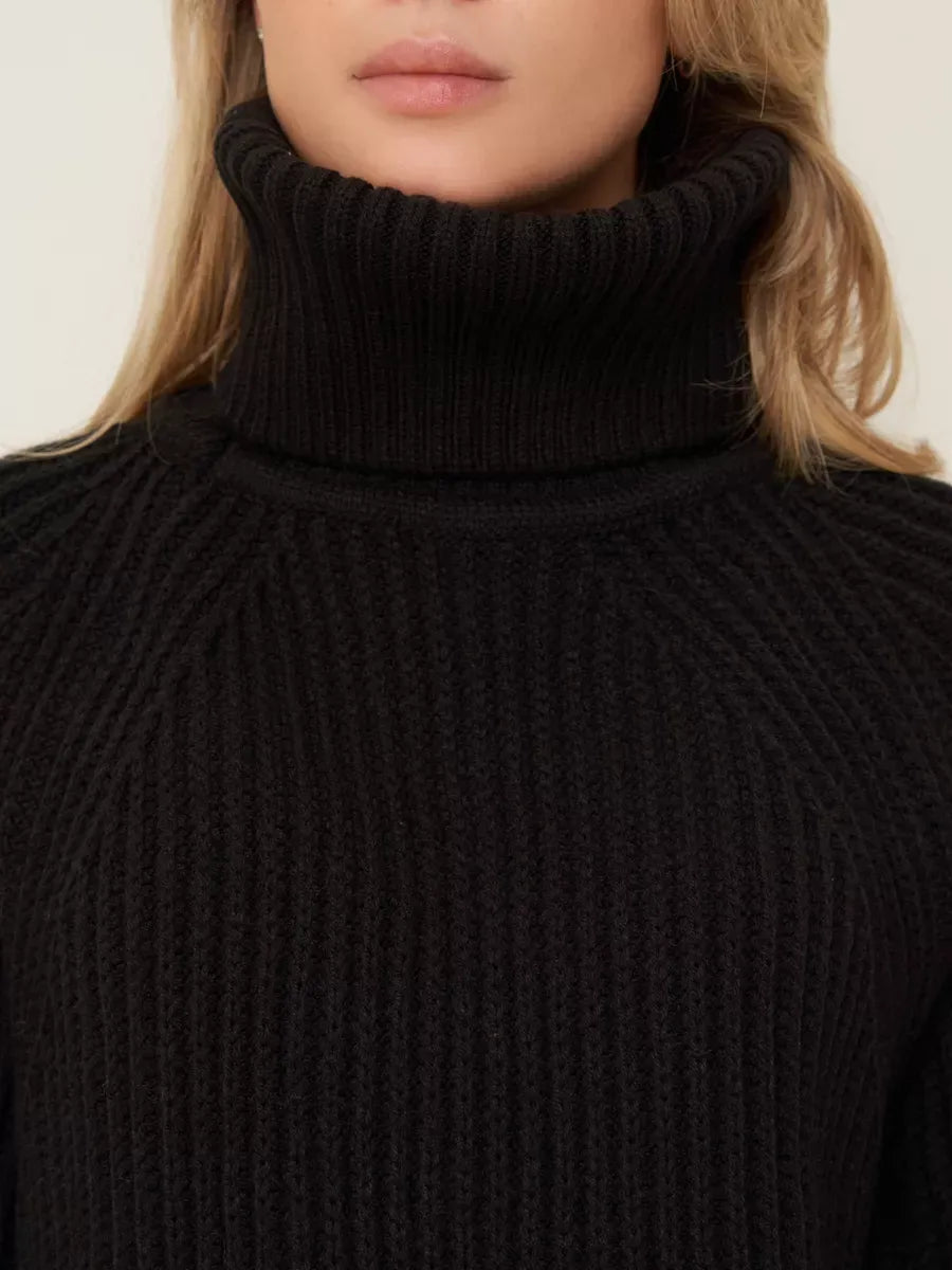 Onyx Sweater by Lauven featuring a cozy turtleneck and oversized black knit design for winter comfort.