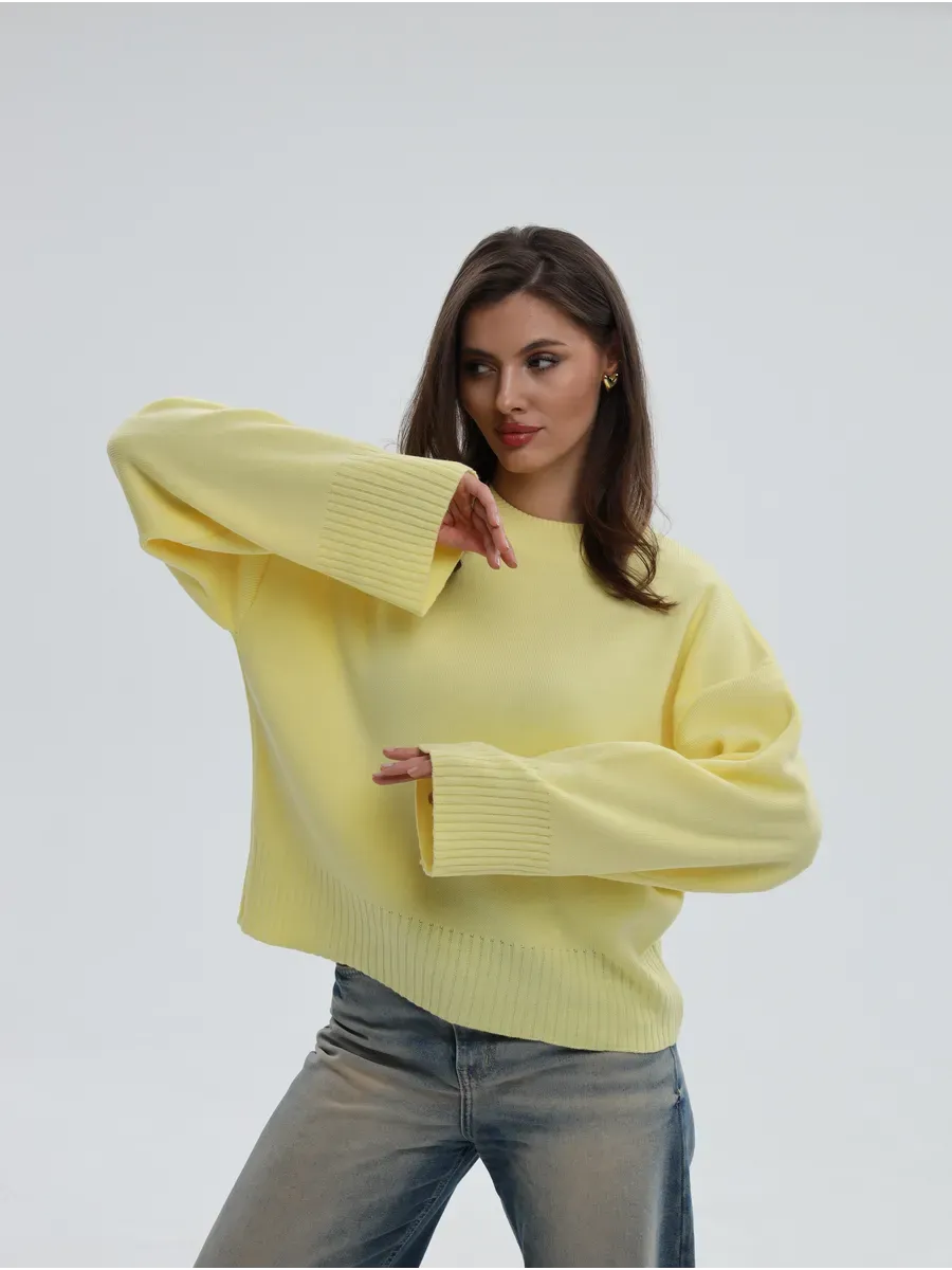 Model wearing the Solara Sweater by Lauven, a light yellow oversized knit with cropped elegance.