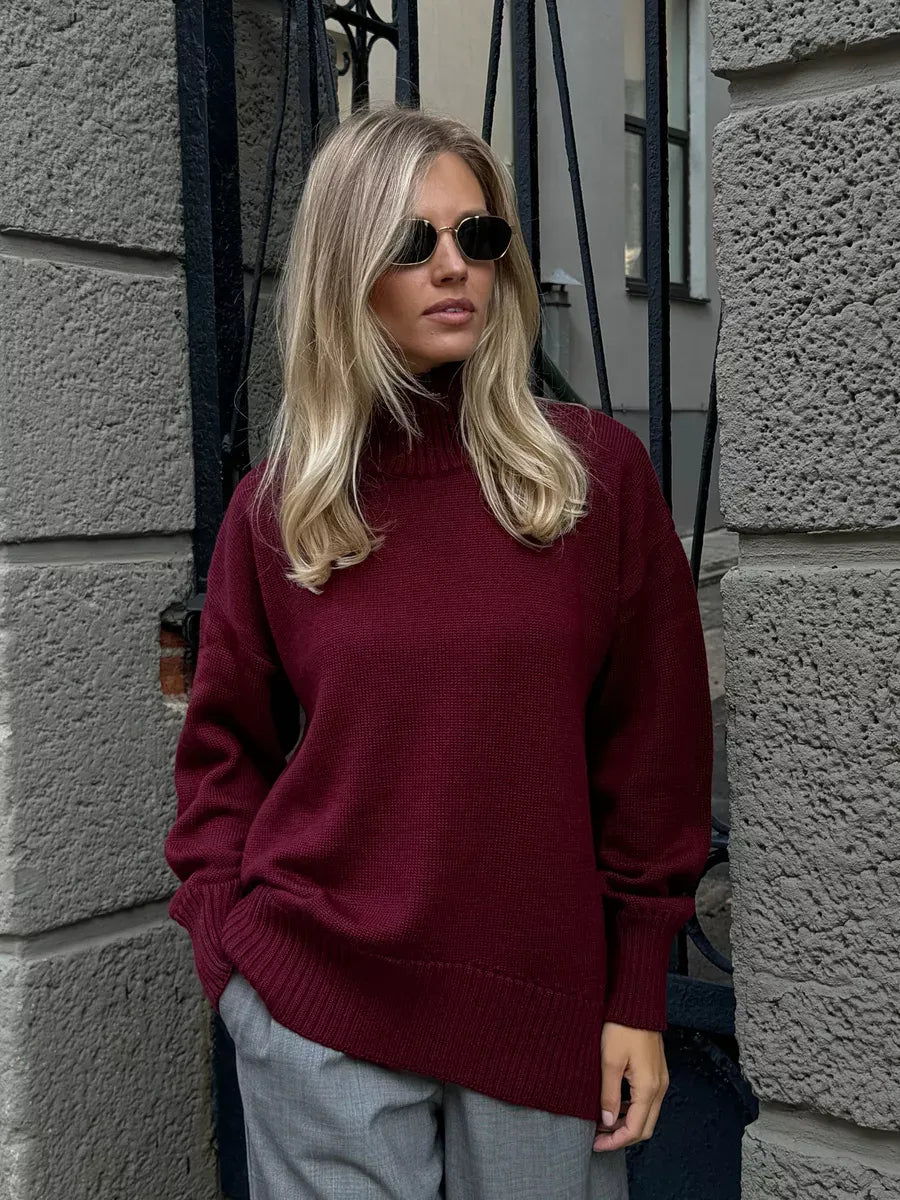 Aurelia Sweater in burgundy, oversized wool knit with high turtleneck, styled by a model with sunglasses, Lauven brand.