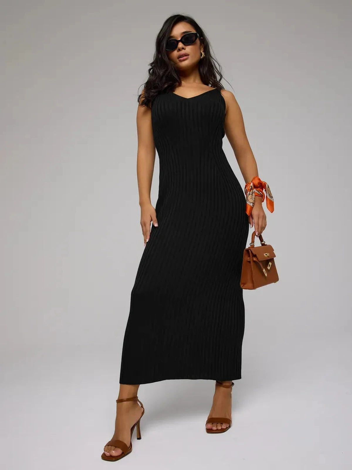 Woman wearing Noir Maxi Dress by Lauven, a sleek black ribbed knit dress, perfect for any elegant occasion.