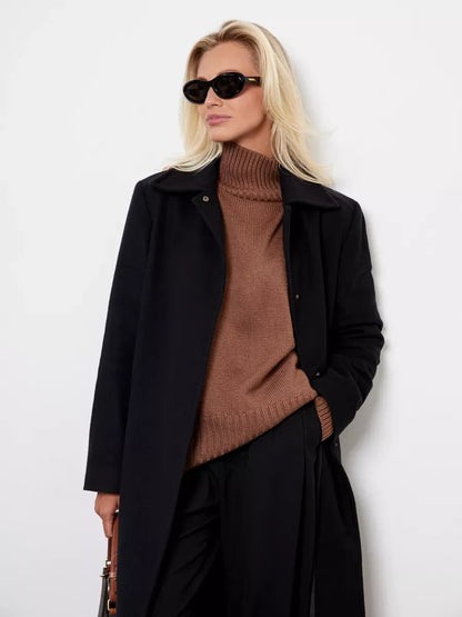 Model wearing Maple Sweater in cocoa brown with black coat and sunglasses, showcasing cozy style by Lauven.