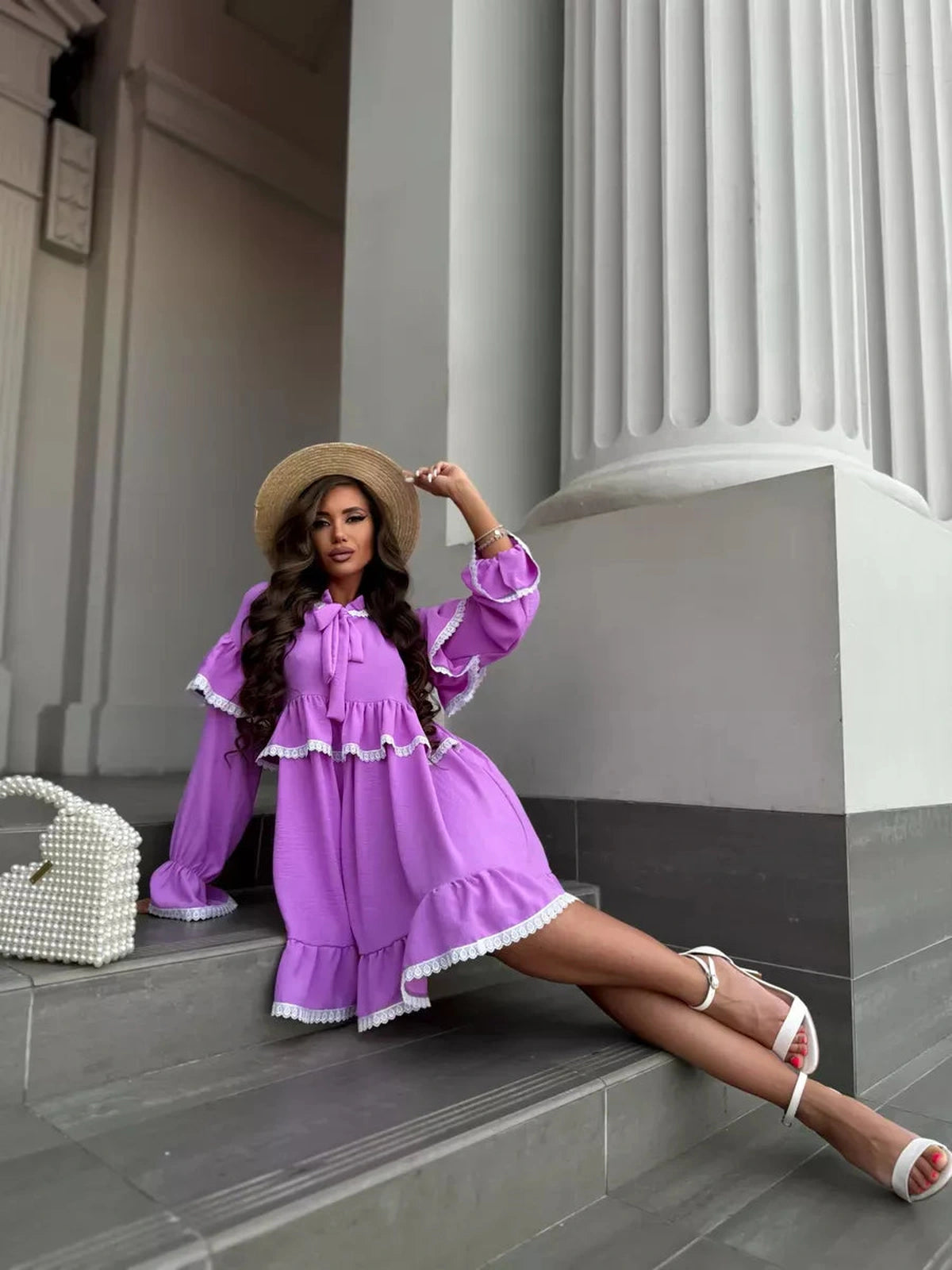 Model showcasing the Violetta Mini Dress by Lauven, featuring delicate lace and flowing ruffles in a lilac color.