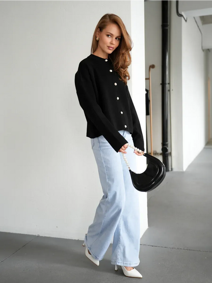 Model wearing the Obsidian Cardigan by Lauven, showcasing stylish black knitwear paired with wide-leg jeans.