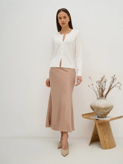 Elegant model in Selene Cardigan by Lauven, showcasing a white knitwear with button closure and a stylish pink skirt.