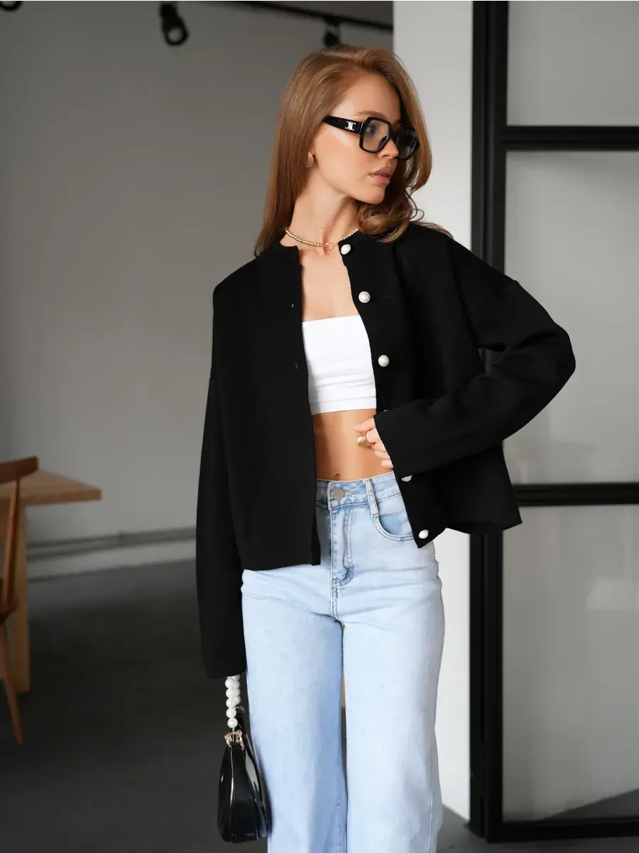 Model wearing Obsidian Cardigan from Lauven, a warm black knitwear with button closure, styled elegantly.