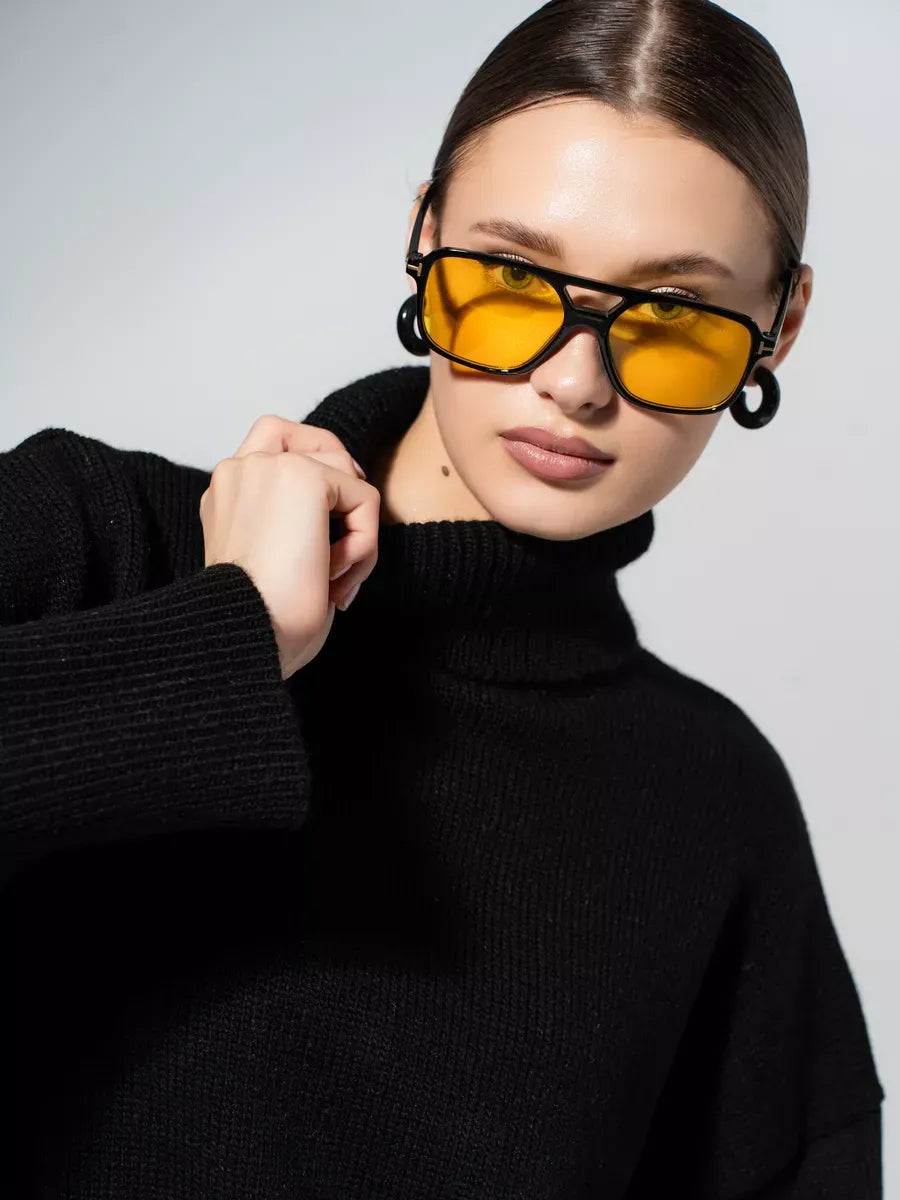 Model wearing oversized Onyx Sweater with yellow sunglasses, showcasing a stylish look in classic black.