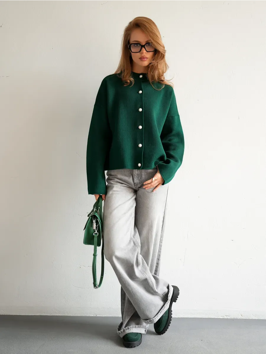 Stylish model wearing Verdant Cardigan by Lauven, a warm emerald knitwear piece with a button closure.