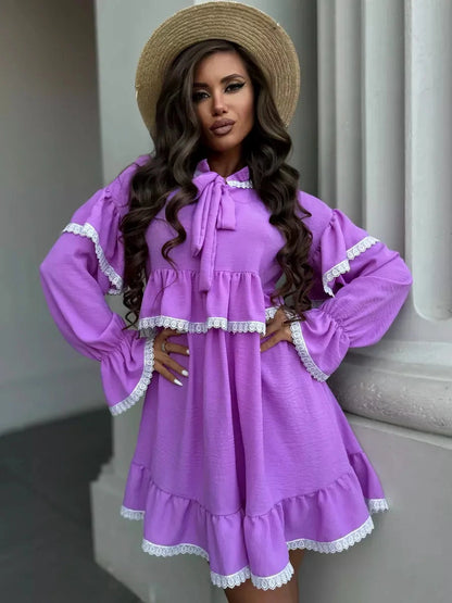 Model wearing the Violetta Mini Dress by Lauven, featuring delicate lace and flowing ruffles in a lilac shade.