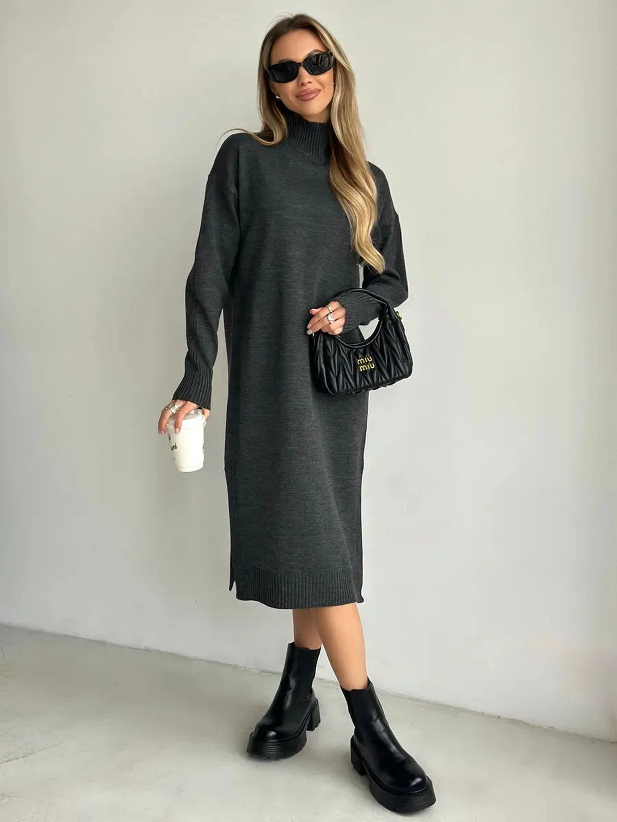 Asteria Midi Dress by Lauven in cozy knit, featuring a high collar and side slit, styled with sunglasses and a handbag.