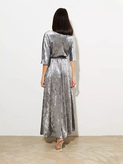 Back view of the Selene Maxi Dress by Lauven, showcasing shimmering silver velvet and elegant flowing design.