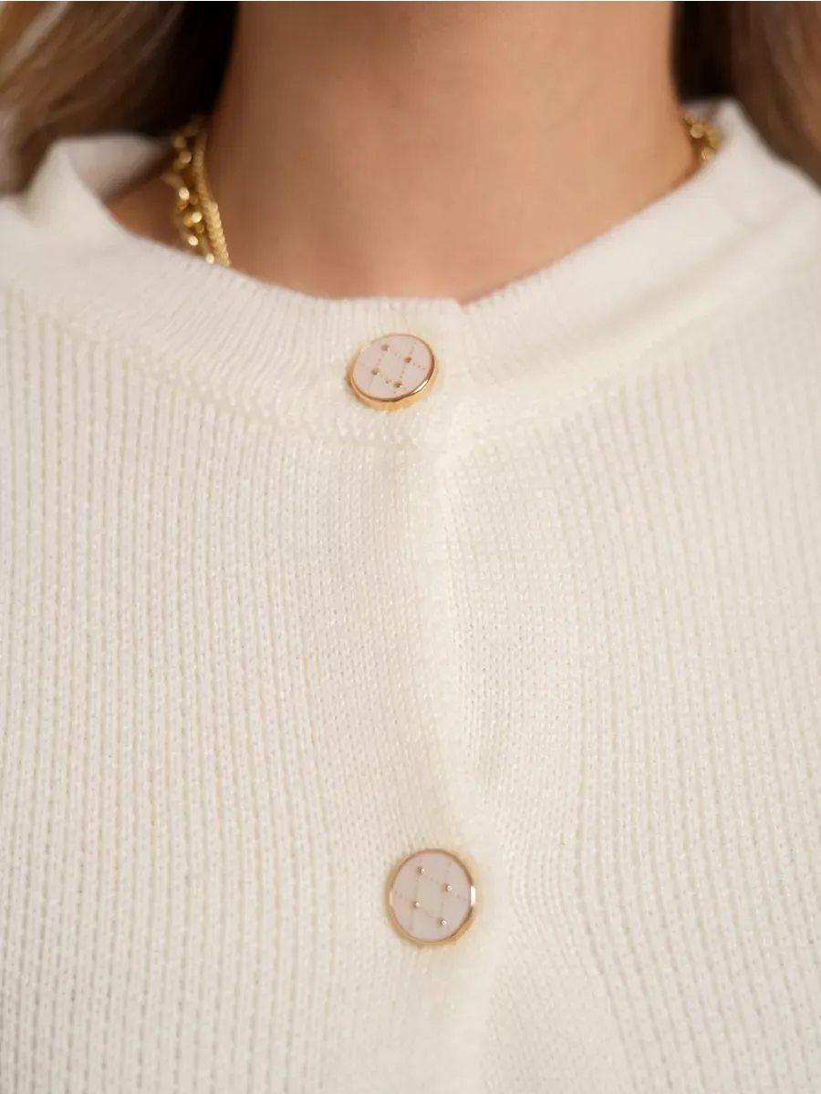 Ivory Cardigan by Lauven close-up of decorative buttons on creamy white knit fabric.