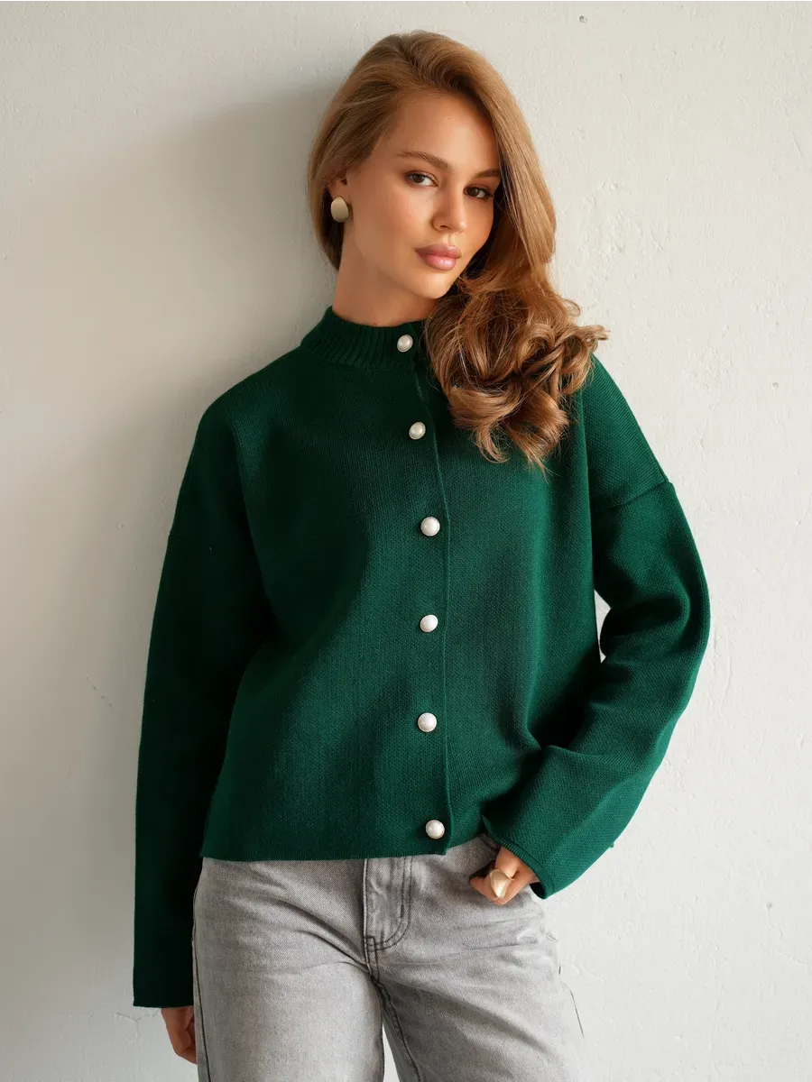 Model wearing Verdant Cardigan by Lauven in warm emerald green with button closure.