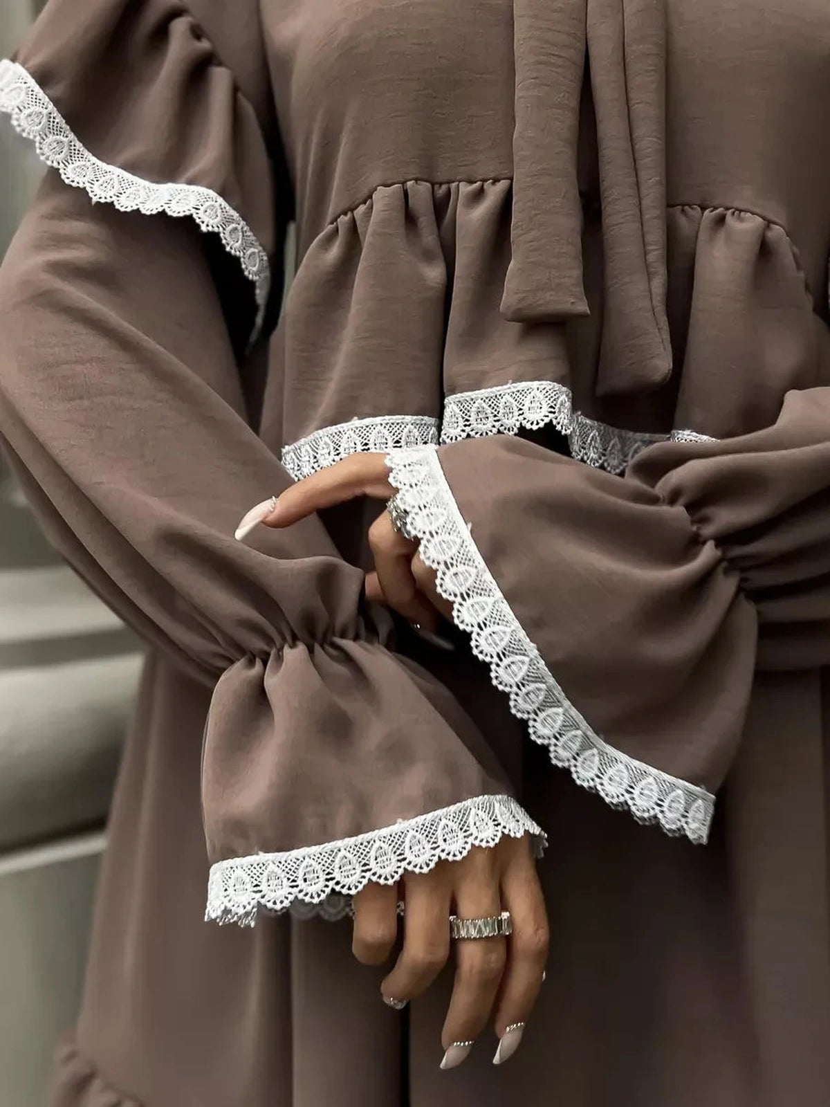 Close-up of the Lauven Aurora Mini Dress, showcasing soft ruffles and delicate lace trim on sleeves.