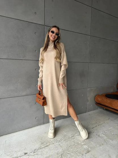 Seren Midi Dress by Lauven, showcasing a woman in a beige knit dress with long sleeves and a side slit in a modern setting.