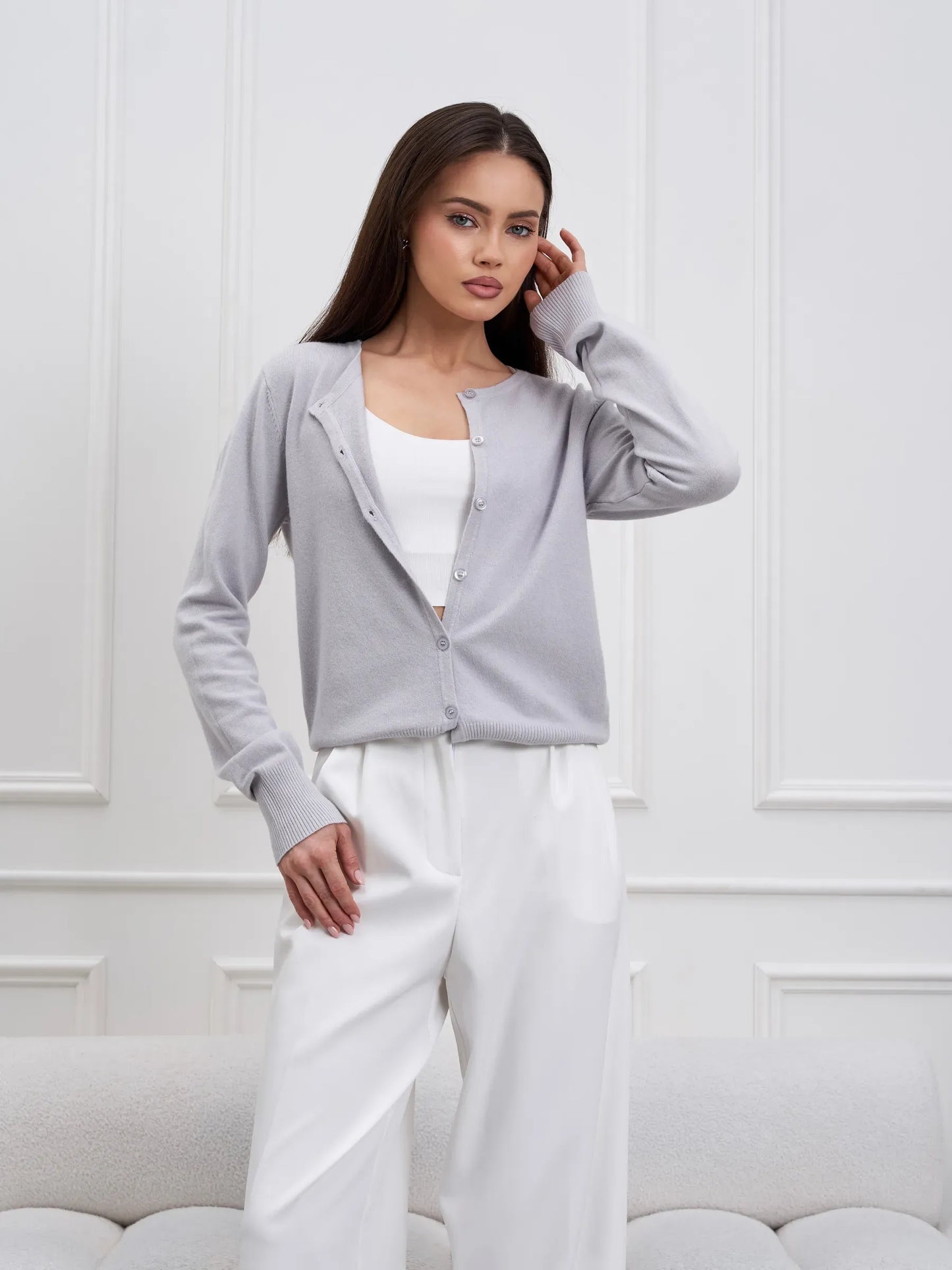 Luna Cardigan by Lauven - Soft grey knitwear with classic button closure, worn with white trousers in a stylish setting.