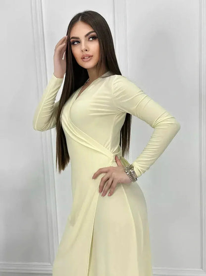 Model showcasing the Celeste Wrap Maxi Dress in buttercream, featuring elegant draping and a sleek silhouette.