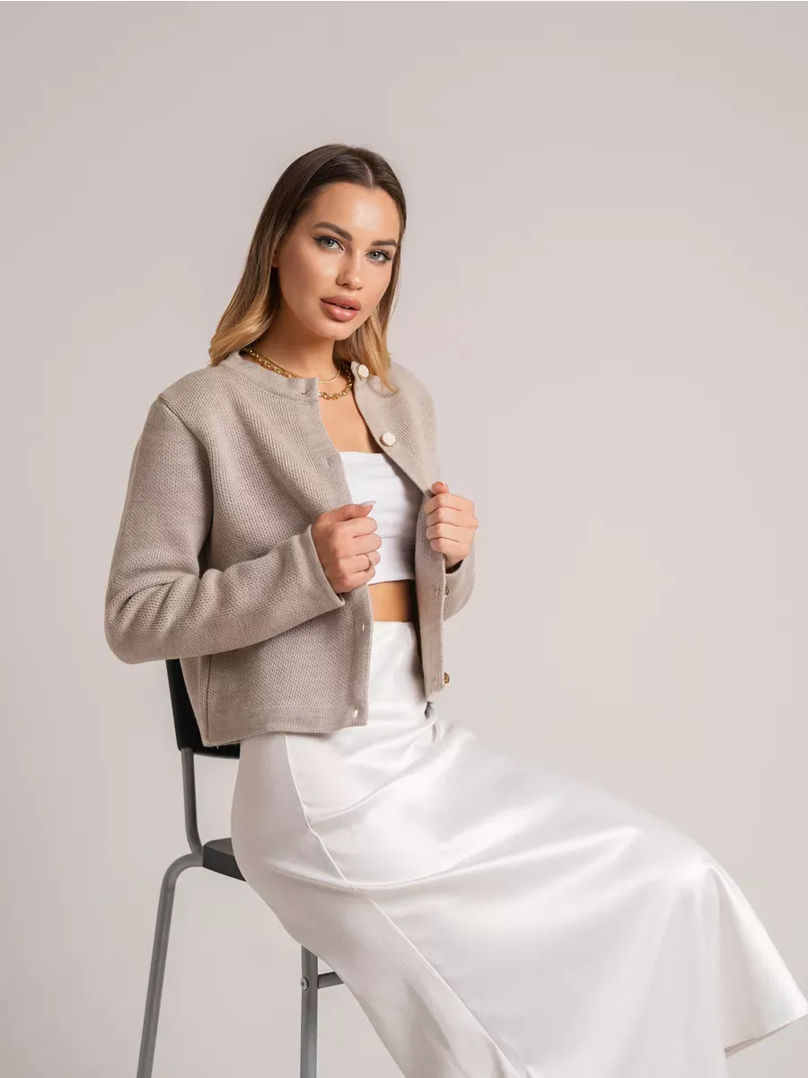 Model wearing Alba Cardigan in beige, showcasing short loose fit knit and decorative buttons, from Lauven.