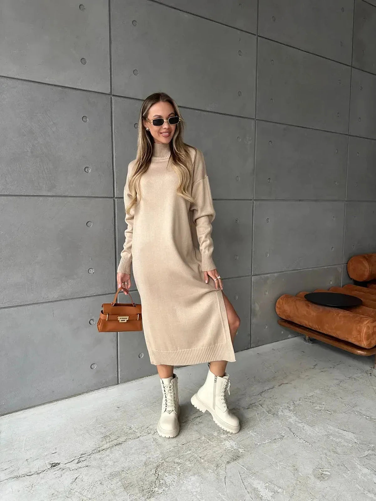 Model wearing the Seren Midi Dress in beige, showcasing minimalist knit sophistication by Lauven.