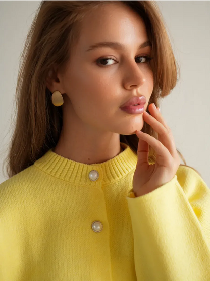 Model wearing a warm yellow Lemonade Cardigan by Lauven with button closure and chic cropped silhouette.