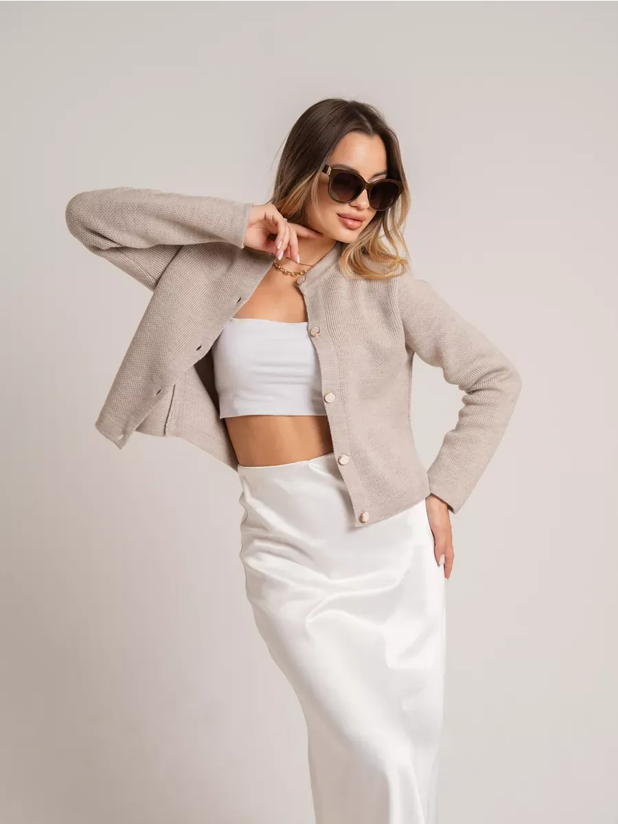 Model showcasing the Alba Cardigan by Lauven, a beige short loose fit knit with decorative buttons.