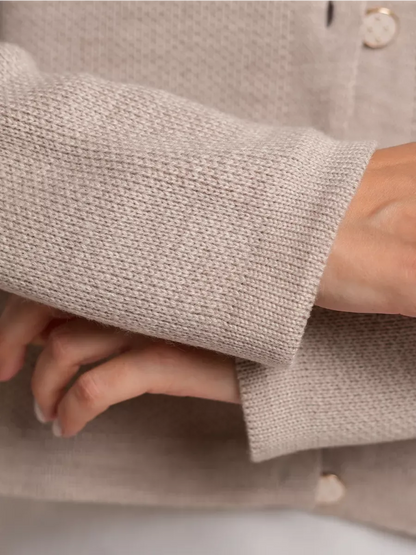 Close-up of Alba Cardigan by Lauven showing beige knit texture and decorative buttons.