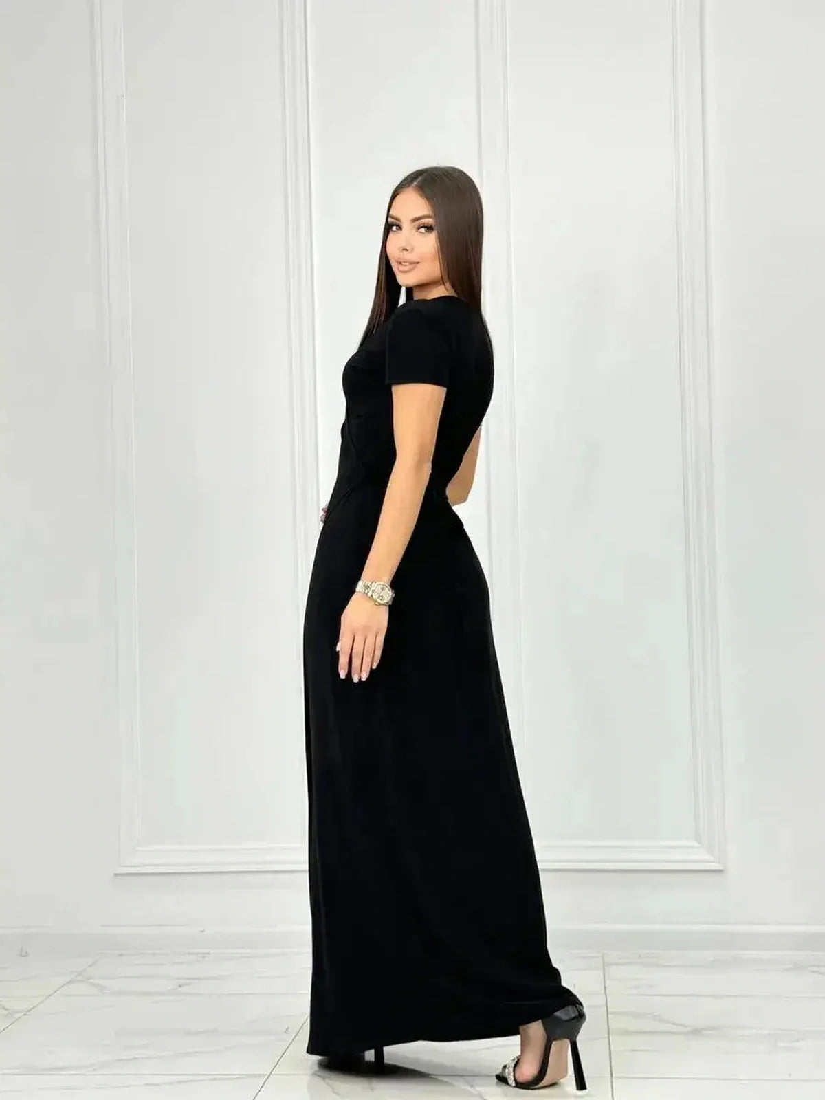 Model showcasing the Obsidian Grace Maxi Dress, an elegant black wrap dress perfect for any occasion.