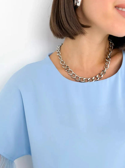 Celeste Blouse by Lauven, featuring a light blue silk-like top with tulle details and a stylish silver chain necklace.