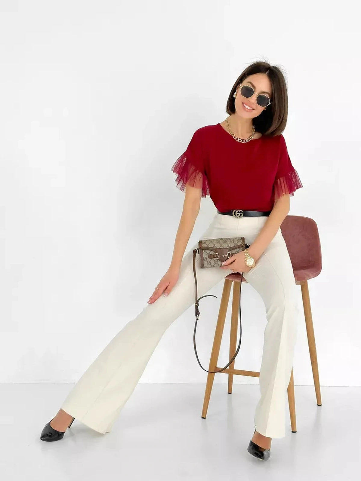Velora Blouse by Lauven, burgundy short sleeve blouse with sheer ruffle sleeves, styled with white pants and accessories.