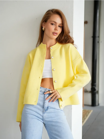 Young model wearing a warm yellow Lemonade Cardigan by Lauven with button closure and cropped silhouette.