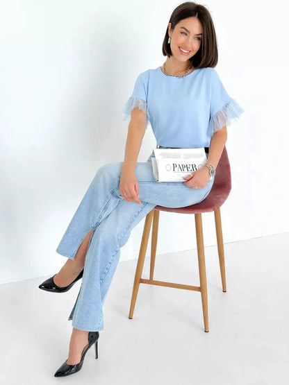 Celeste Blouse by Lauven, light blue silky short sleeve top with tulle details, styled with jeans and high heels.
