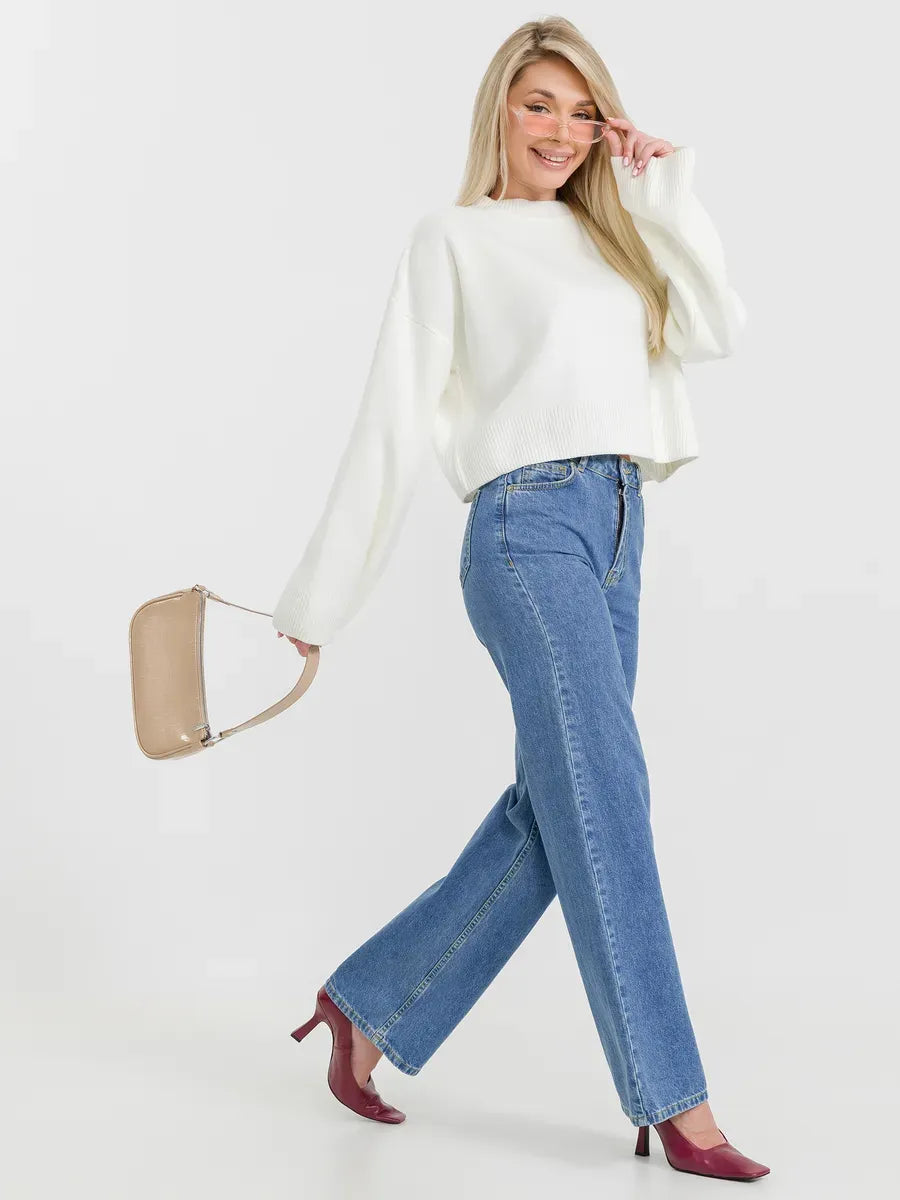 Woman wearing the Luna Sweater in ivory with high-waisted jeans, styled for a chic and casual look.