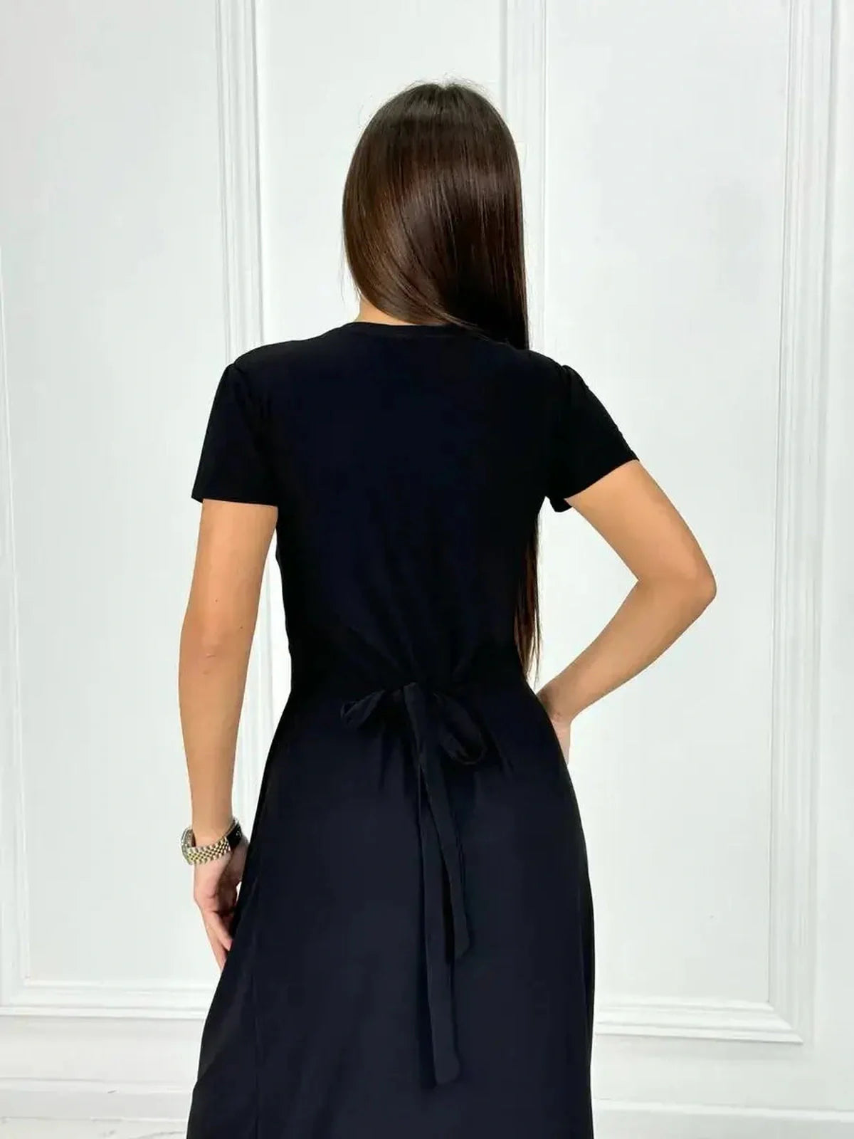 Back view of the elegant Obsidian Grace Maxi Dress showcasing its wrap silhouette and chic black fabric.
