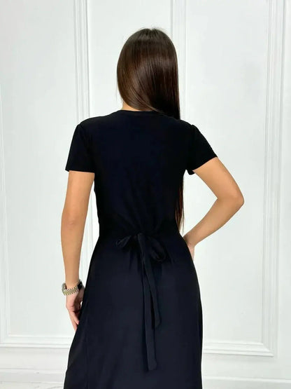Back view of the elegant Obsidian Grace Maxi Dress showcasing its wrap silhouette and chic black fabric.