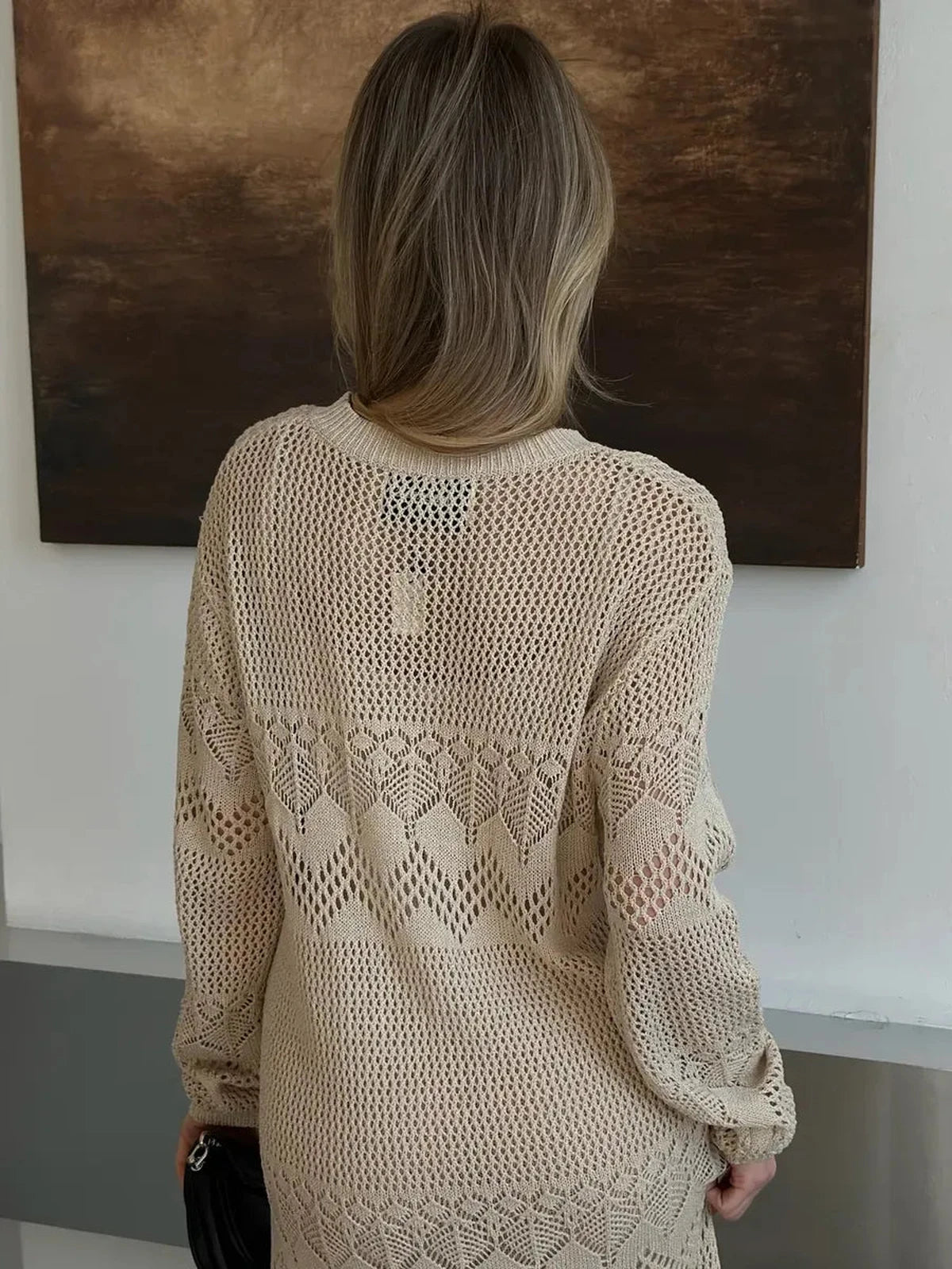 Woman wearing Verona Maxi Dress by Lauven, showcasing elegant beige crochet knit from the back.