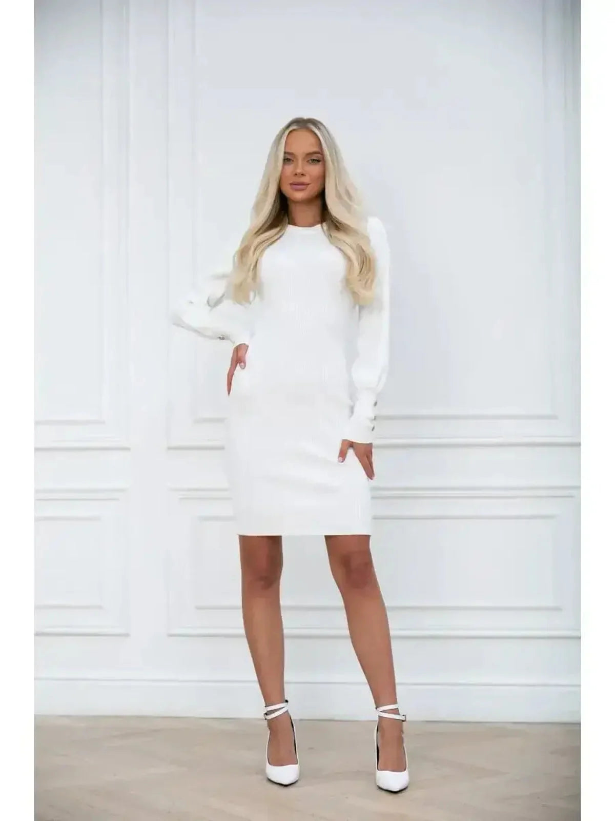 Model showcasing the Ivory Curve dress, a fitted white mini dress with long voluminous sleeves and structured cuffs.